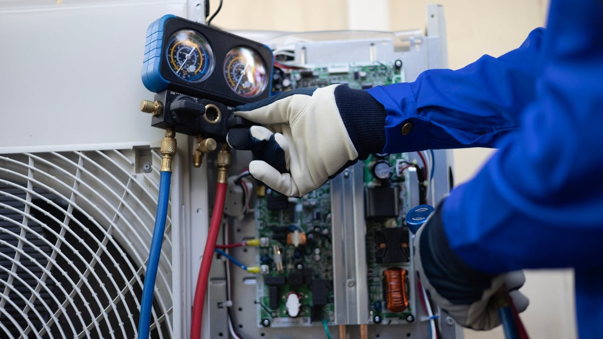HVAC technician performing maintenance on condenser unit
